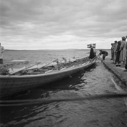 Motiv: (ingen anteckning) ;
En man i folkdräkt står i en kyr