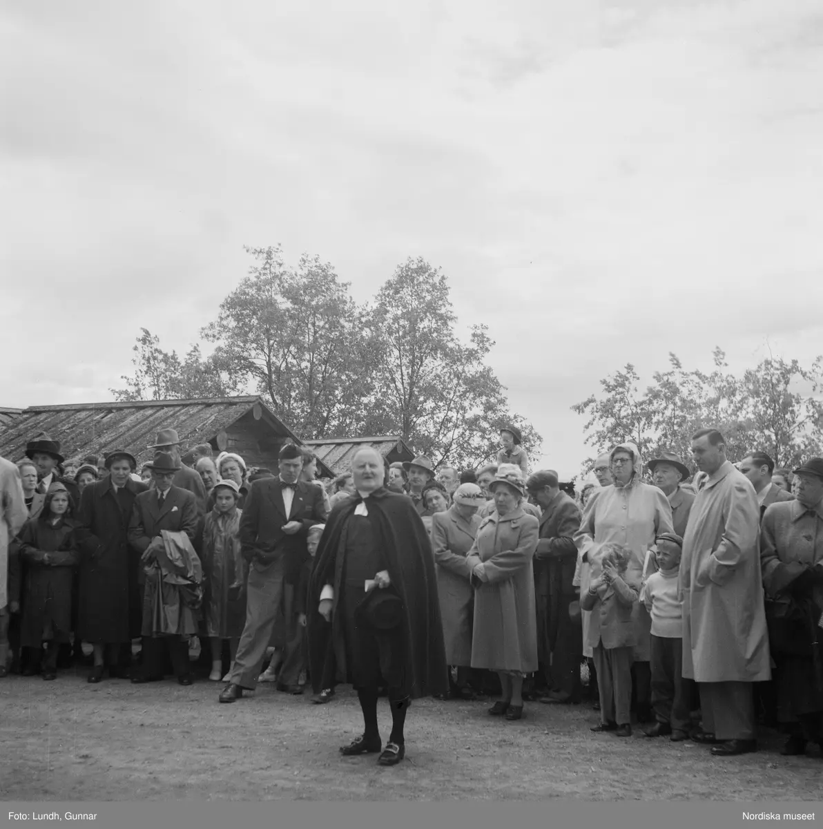 Motiv: (ingen anteckning) ;
En folksamling vid Rättviks kyrka, en folksamling står vid en brygga när kvinnor och män går ombord på två kyrkbåtar.