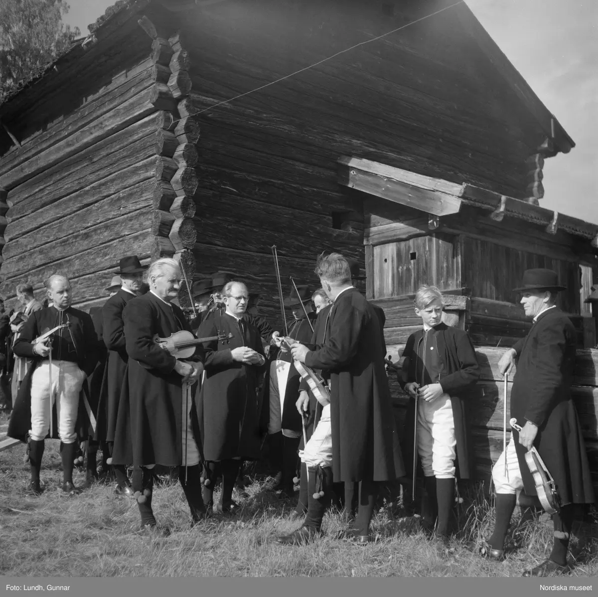 Motiv: (ingen anteckning) ;
Porträtt av en man - ett barn och en kvinna i folkdräkt, två kvinnor i studentmössor, män klädda i folkdräkt spelar fiol.