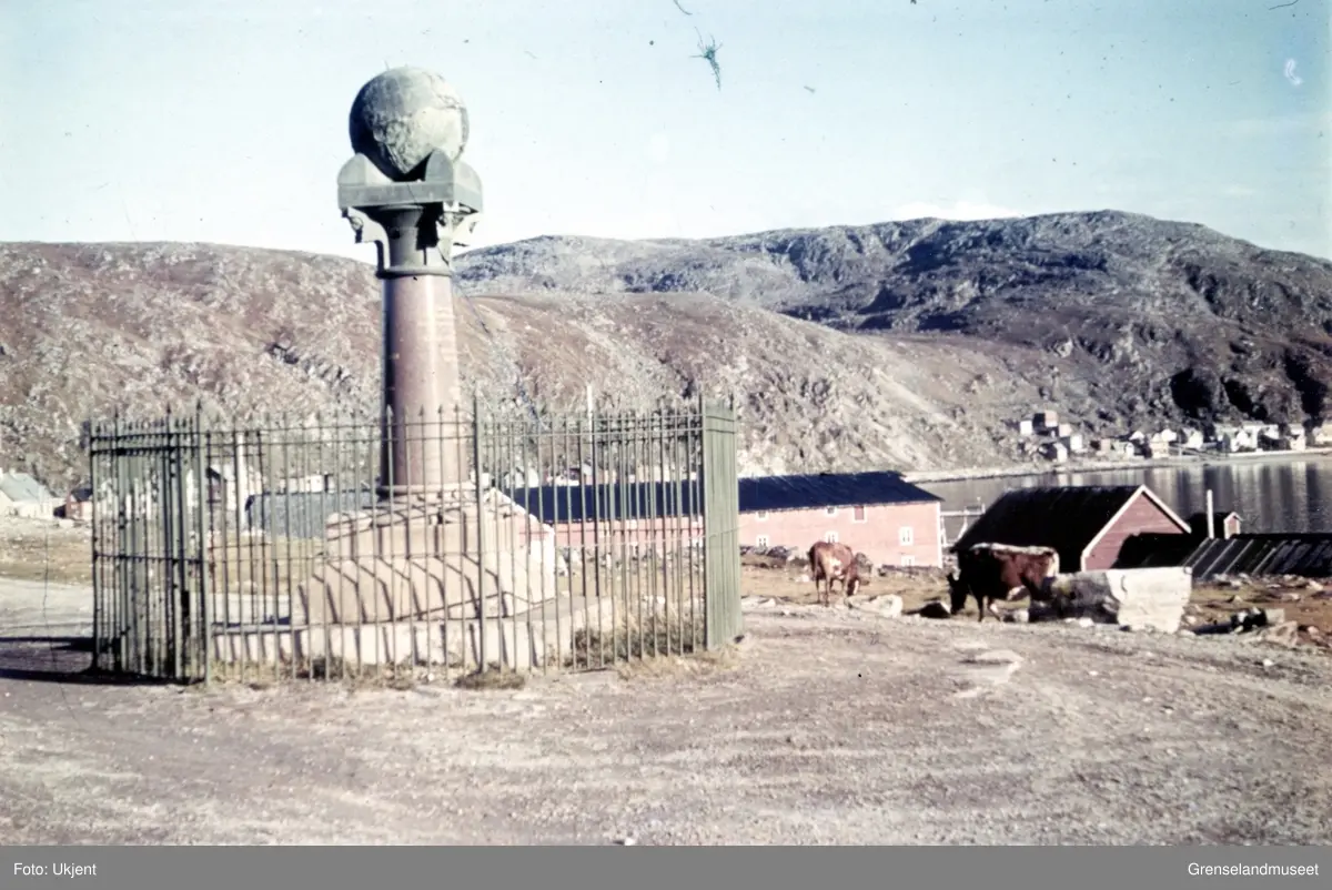 Struves meridianbue - Meridianstøtten på Fuglenes i Hammerfest. Det går noen gressende kyr til høyre for meridianstøtten.