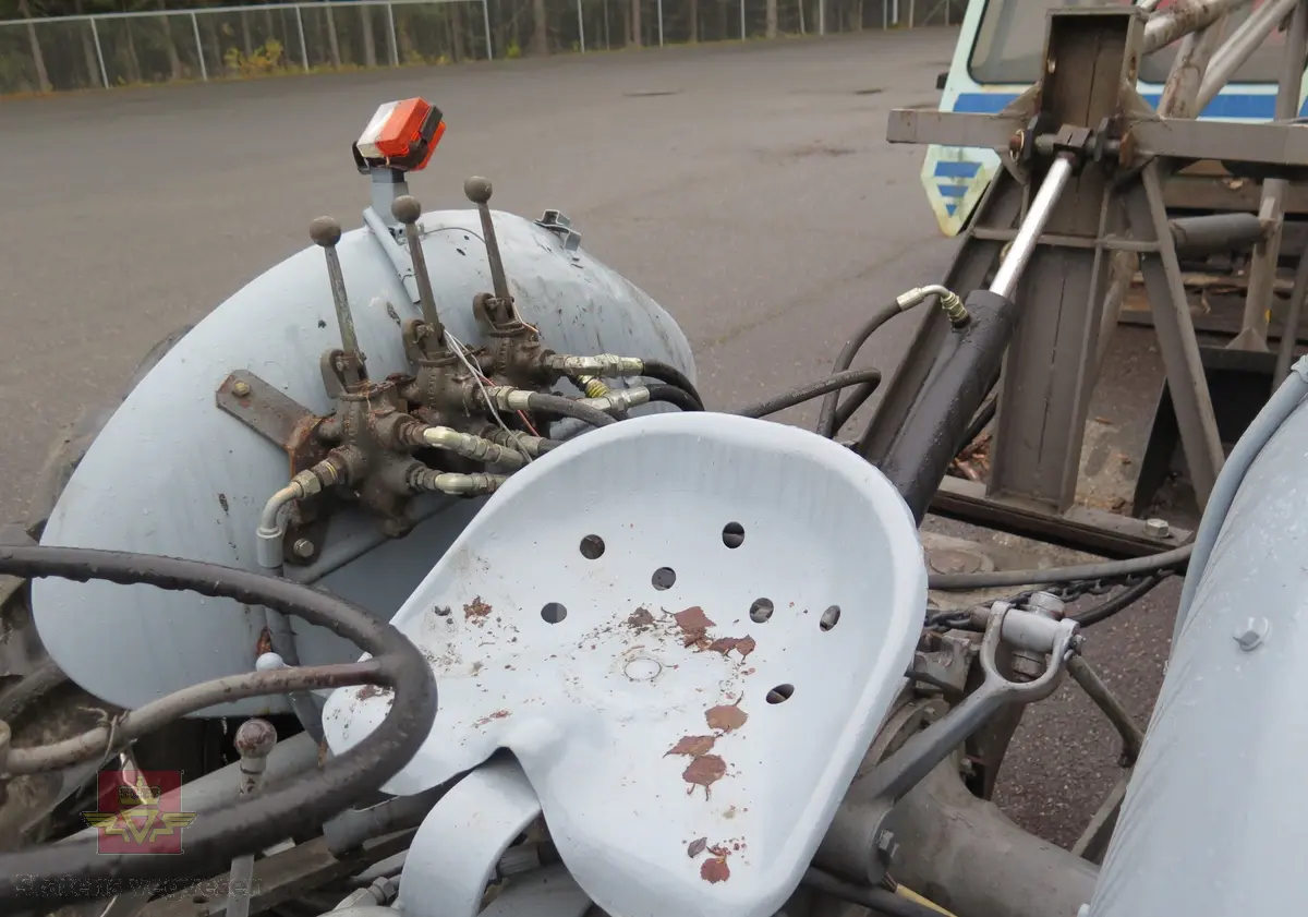 Ferguson TEA20. Grå traktor med lasteapparat foran og graveaggregat bak. Motoren er en 4-sylindret bensinmotor fra Standard Motor Company.