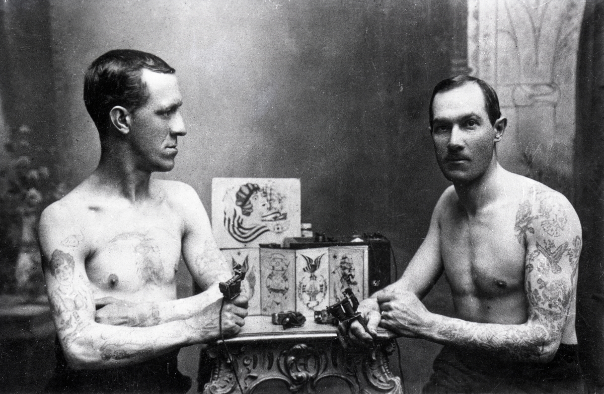 Tatueraren Carl Gustafsson i verksamhet. "Tatueringskalle". Foto i Gustafssons ateljé, Göteborg.

[Gustafsson till höger i bild. Till vänster Axel Wilhelm Johansson.]