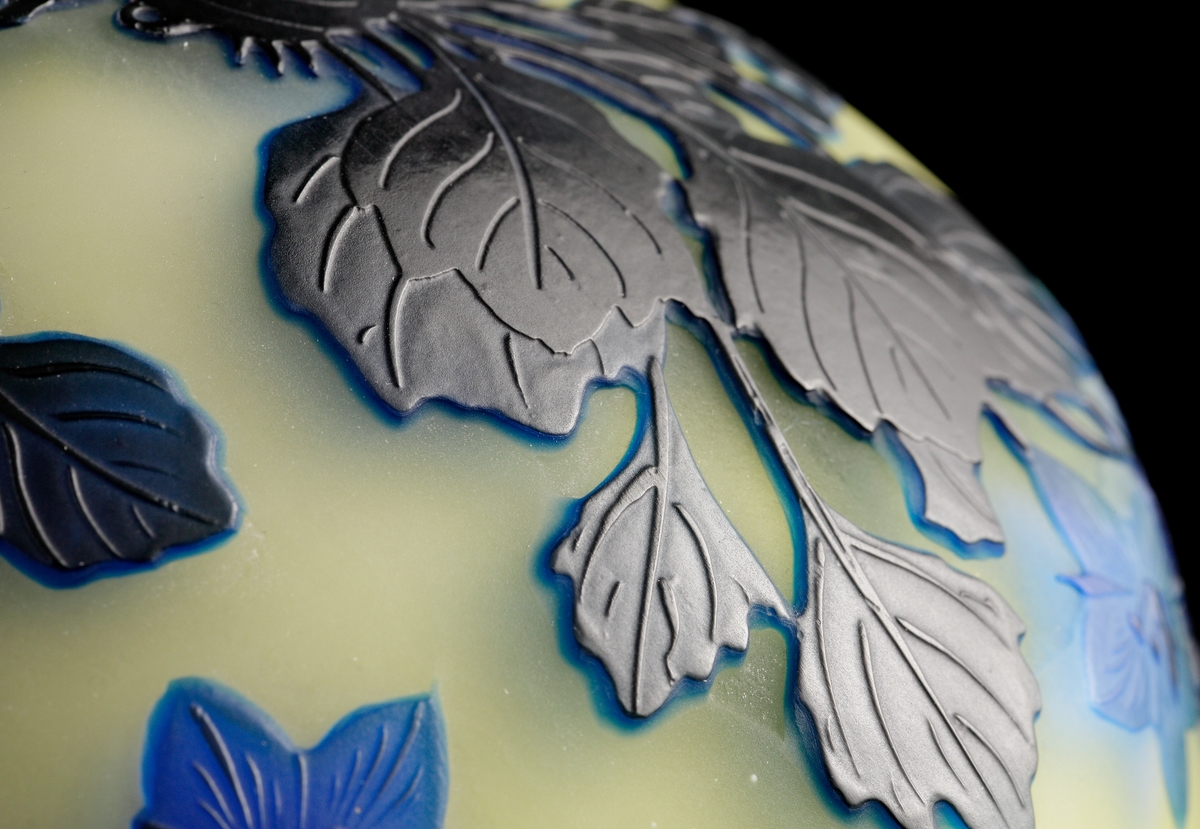 Opak, gul lampa med etsat överfång i olika blå nyanser.
Metallfattning för glödlampa. Tvinnad textilsladd.