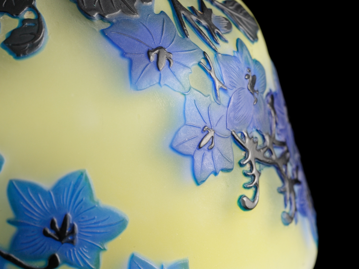 Opak, gul lampa med etsat överfång i olika blå nyanser.
Metallfattning för glödlampa. Tvinnad textilsladd.