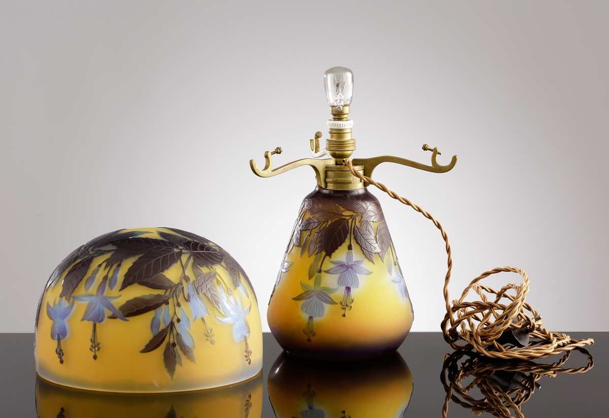 Gul opak lampa med växtmotiv. Etsat överfång i blått och gråbrunt.
Metallfattning för glödlampa. Tvinnad textilsladd.