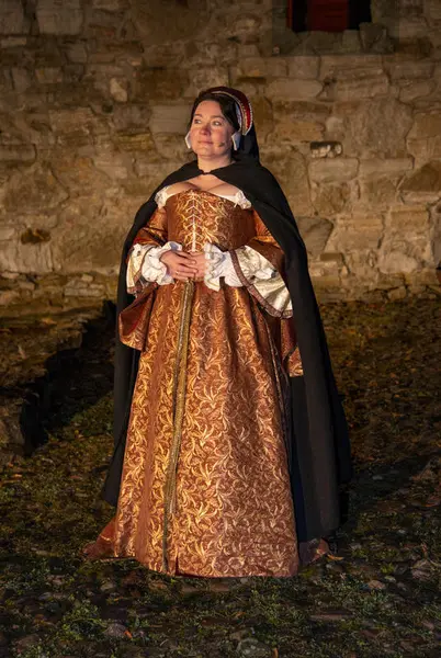 Jomfru Karine står i fint lys med den vakre kjolen og hodepynten sin.