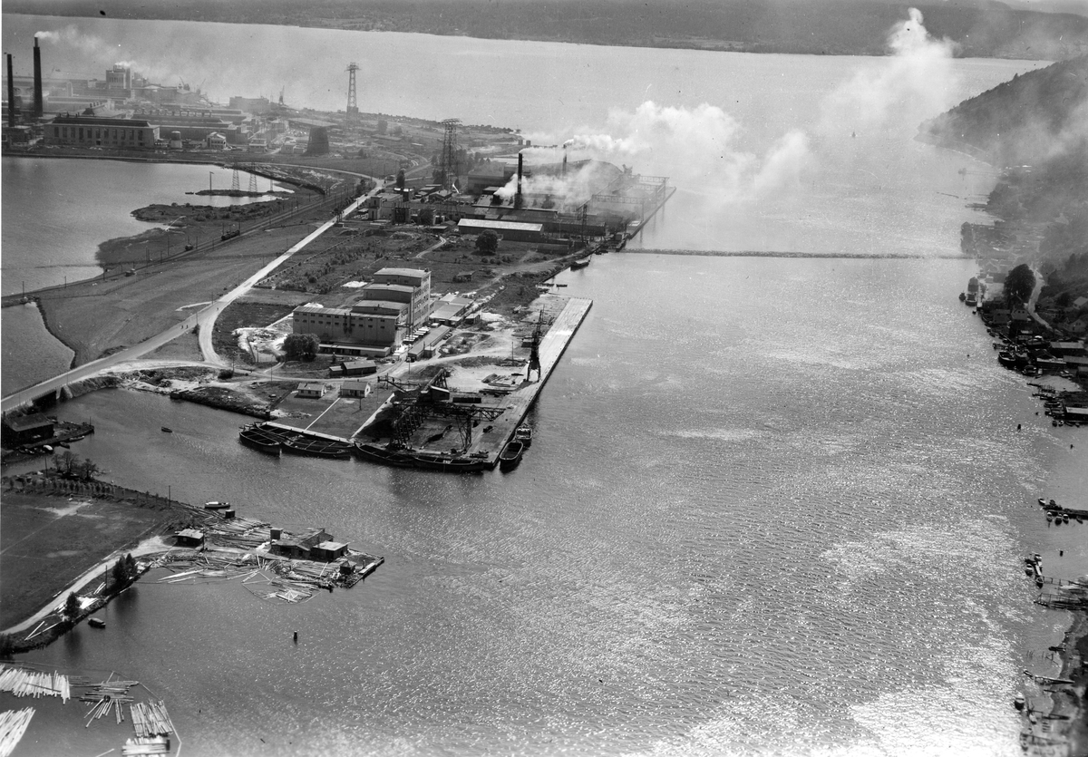 Flyfotoarkiv fra Fjellanger Widerøe AS, fra Porsgrunn Kommune. Porsgrund Porselæns Fabrik A/S Sanitærporselenen. Elkem Porsgrunn, kaianlegg med råstofflager. Fotografert 14.06.1955. Fotograf Otto Hansen.