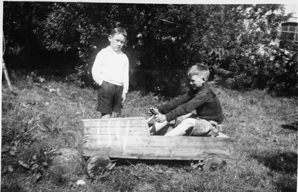 Heimelaga leikebil frå Netland. Per Netland (1933 - 2013) i bilen og Paul Netland (1935 - ) ved sida.