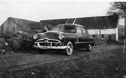 Bil på Netland. Den gamle løa i bakgrunnen.