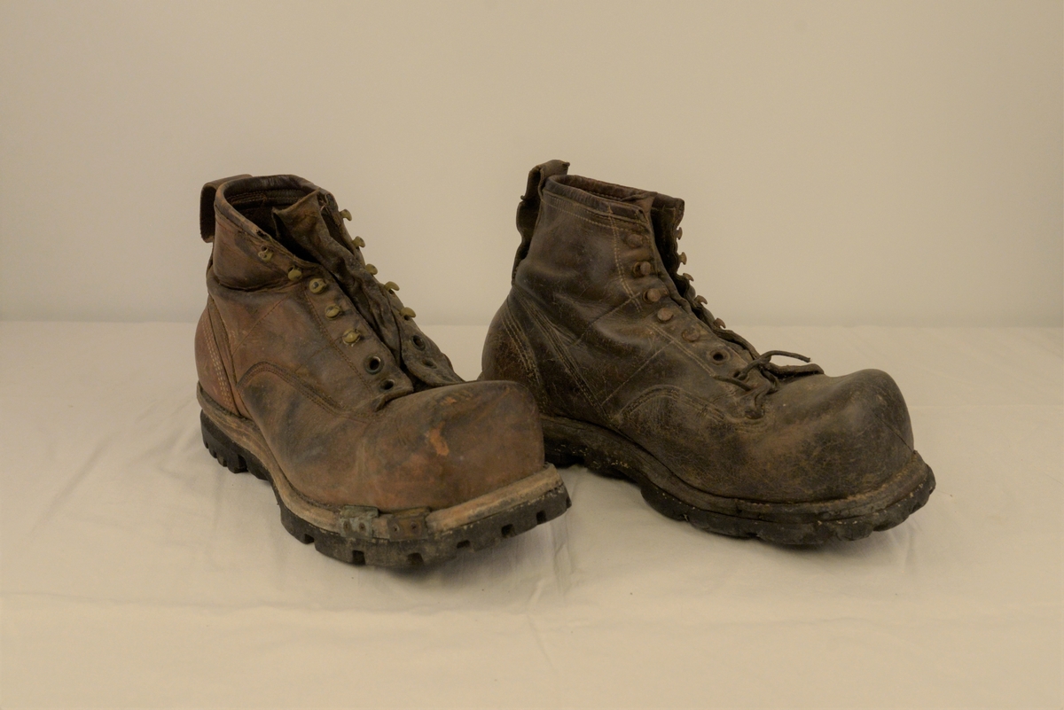 Sko i brunt lær, med gummisåle, maljer for lisser, og hemper for snøring.