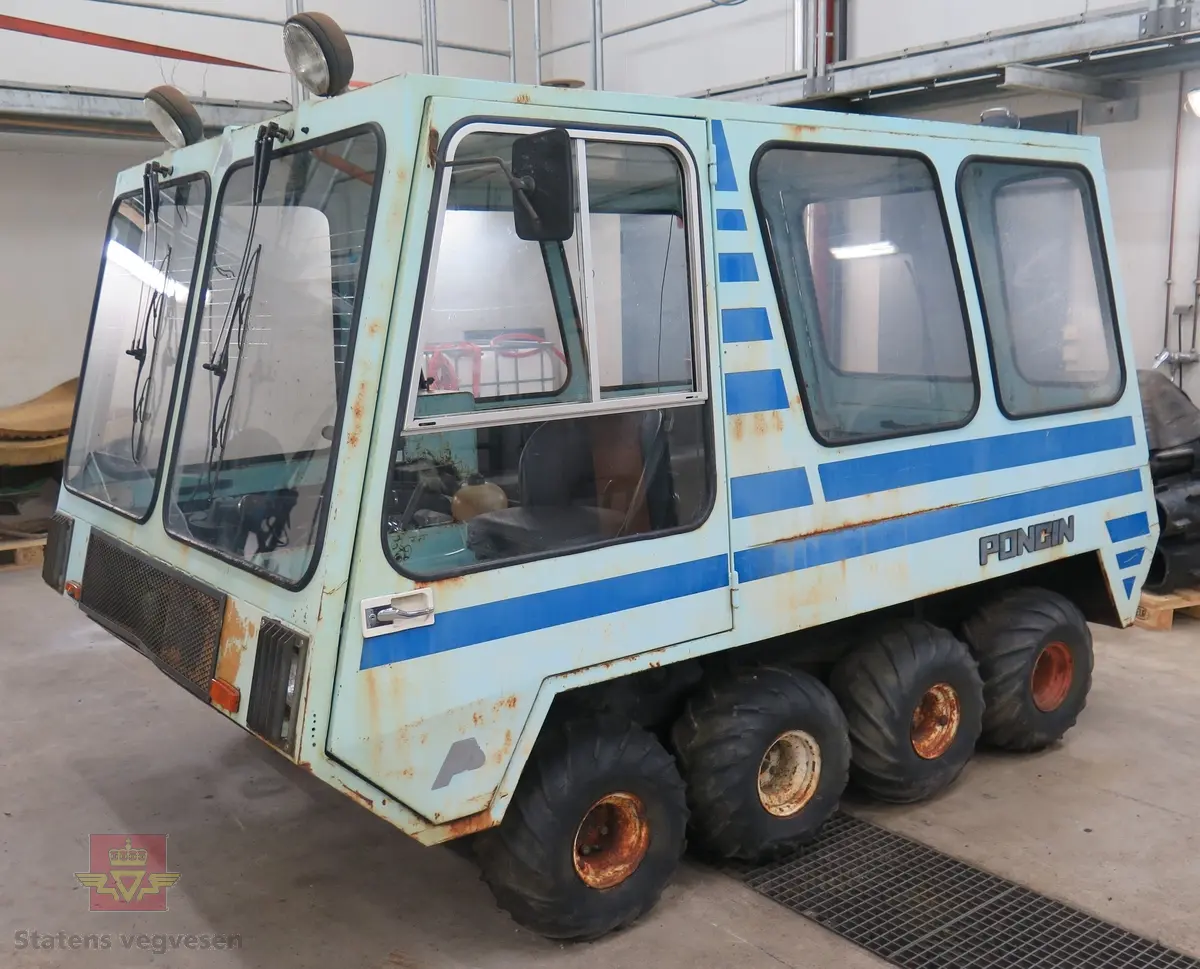 Lyseblå og mørkeblå buss med belter, 8 x 8. 4-sylindret dieselmotor, trolig fra Peugeot eller Renault. Kan brukes både som hjul- og som beltebuss.