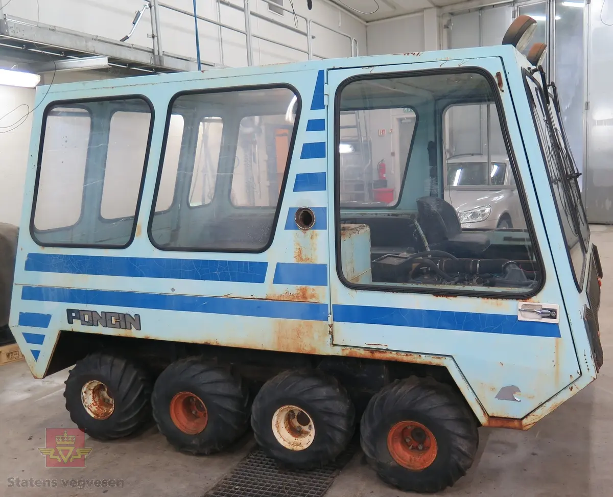 Lyseblå og mørkeblå buss med belter, 8 x 8. 4-sylindret dieselmotor, trolig fra Peugeot eller Renault. Kan brukes både som hjul- og som beltebuss.