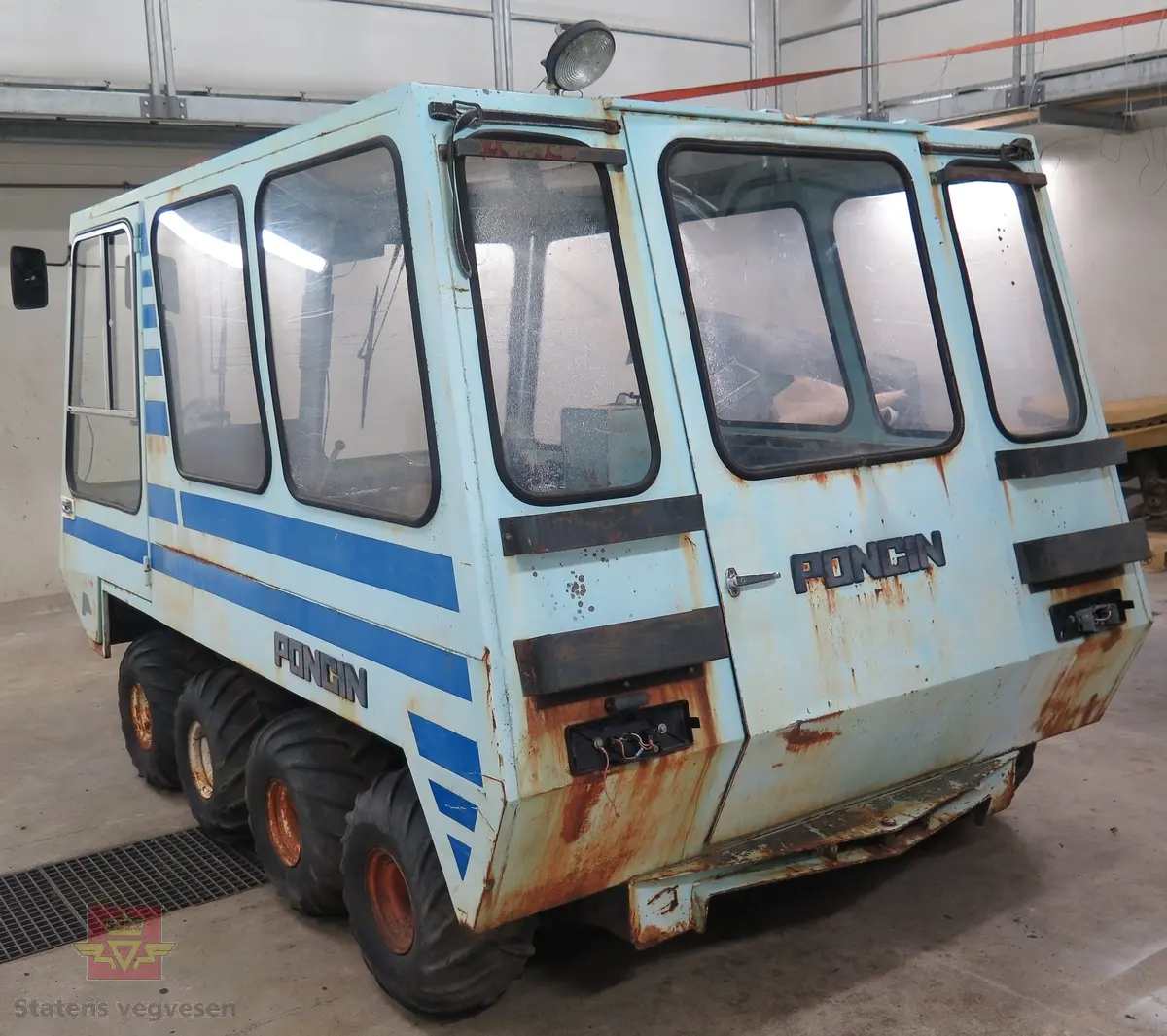 Lyseblå og mørkeblå buss med belter, 8 x 8. 4-sylindret dieselmotor, trolig fra Peugeot eller Renault. Kan brukes både som hjul- og som beltebuss.