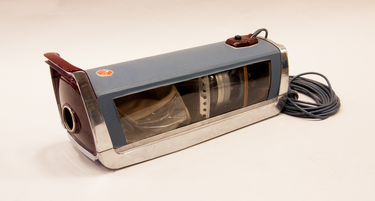 Elektrisk dammsugare, uppskuren demonstrationsapparat, 220 V, 400 W. Elsladd, 3 m lång. (TM29014:1) 
Tillbehör: TM29014:2 slang c:a 750 lång, 2 st rörbitar. TM29014:3 5st tillbehör i plast.