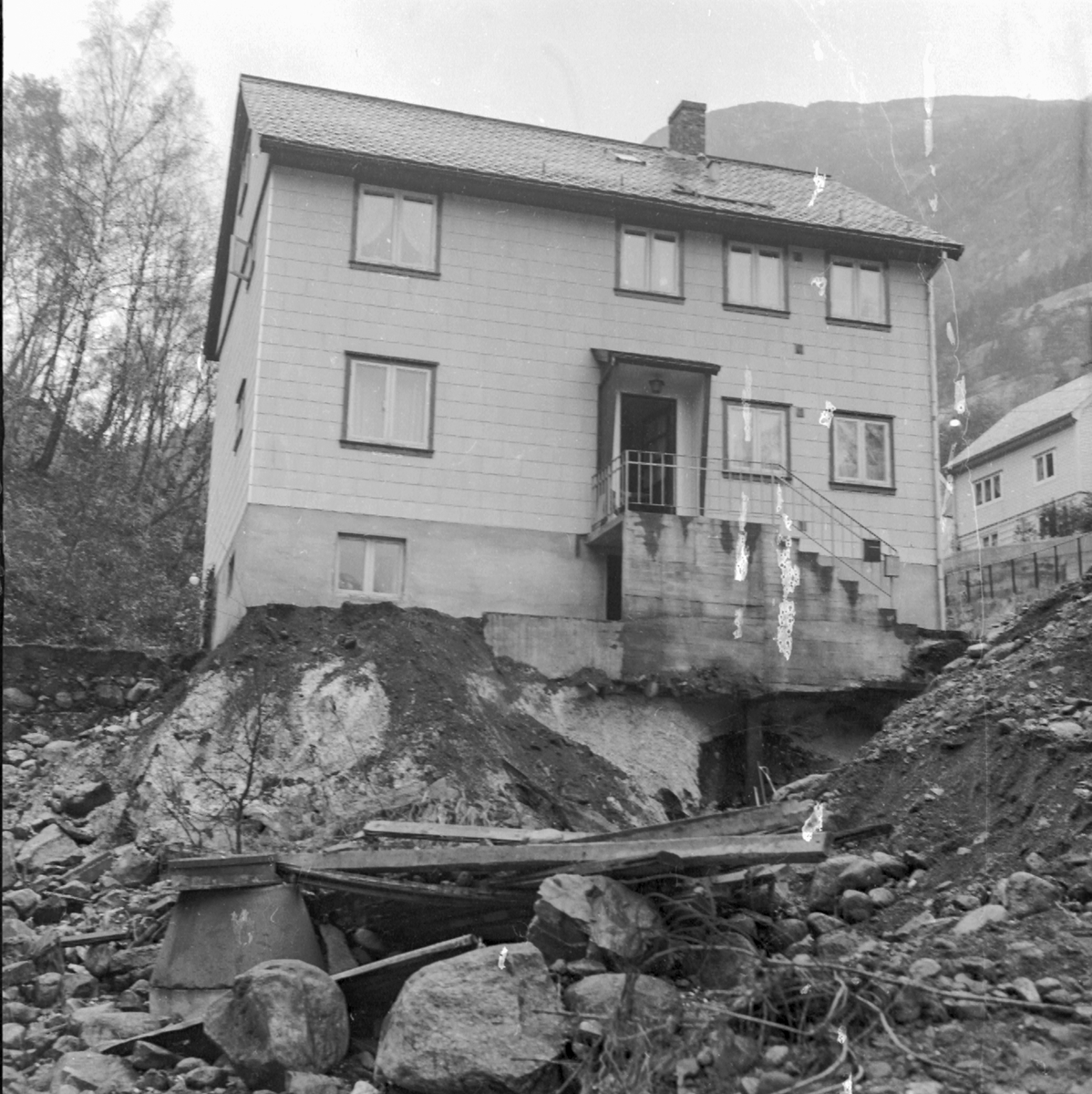 Bustadhus nesten undergravd av Sansarbekken som rann over i Tjoadalen.