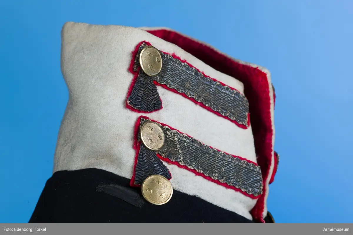 Mörkblå frack med vita detaljer och förgyllda mässingsknappar.

Fracken är sydd av blåsvart fint kläde, med vit, hög krage som i nacken bak går ned i en spets. Uddig guldgalon på kragen och tre knappar av mindre modell än mitt fram. Sidenband på båda axlarna för fastsättning av epåletter. Ärmuppslagen är vita med två guldgaloner på varje med knappar upptill. På bakstycket blindfickor med guldgalon på röd matta; tre stycken med knappar nedanför på frackskörten. Skörten är fodrade med vitt, tunt ylletyg som även använts till uppviken. Två granater som är en symbol för grenadjärerna är broderade  med metalltråd längst ner i skörtens spetsar.
I livet bak sitter två knappar som dekoration. Fram knäpps fracken med 6 stora guldknappar med tre kronor på räfflad botten.
Fracken är konstruerad med fram- och sidstycken i ett. Sidorna går ner och bildar tudelat frackskört bak. Båden har varit fodrad med rött fint ylletyg, troligen en rask. Under konservering har fodret ersatts med rosa sidentyg i sidorna. Ärmarna är fodrade med fint vitt linne, men den nederste delen av ärmen har en infodring av samma röda tyg som i bålen.