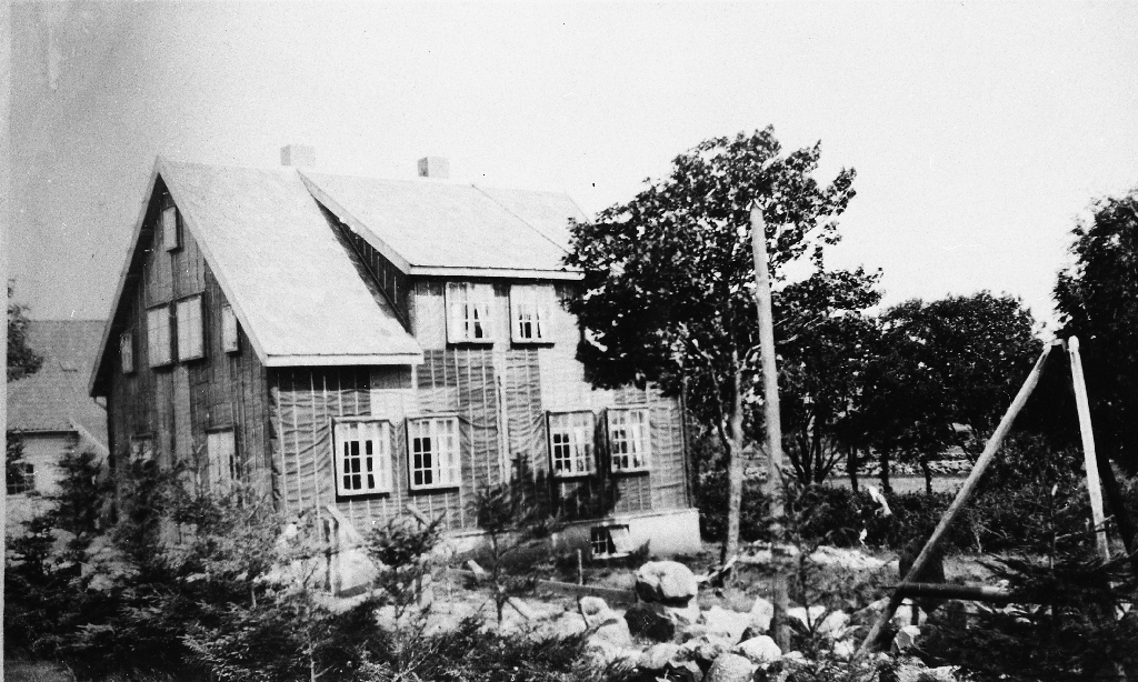 Heimehuset på Heiane i 1924. Huset er nytt og ikkje bordkledd ennå. Til høgre telefonstolpe og steinbukk.