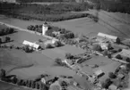 Flygfoto över Alseda i Vetlanda Kommun och på bilden ser man även Alseda Kyrka, Jönköpings län. Nr: 1021/1961