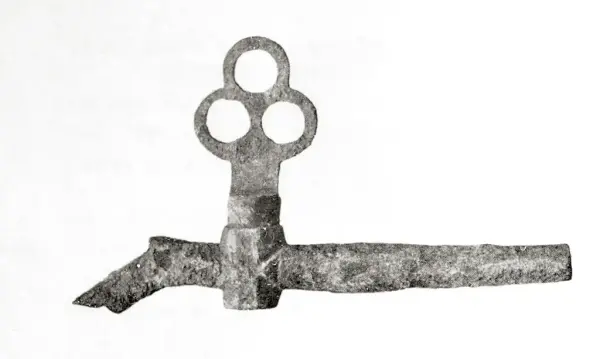 Tverrgående metall"pinne" med liten knekk ned på venstre side. Nokså langt ute til venstre på "pinnen" (som er hul) sitter en slags ventil med et trekløverformet håndtak.