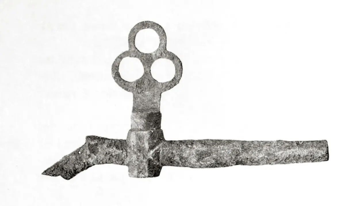 Tverrgående metall"pinne" med liten knekk ned på venstre side. Nokså langt ute til venstre på "pinnen" (som er hul) sitter en slags ventil med et trekløverformet håndtak.