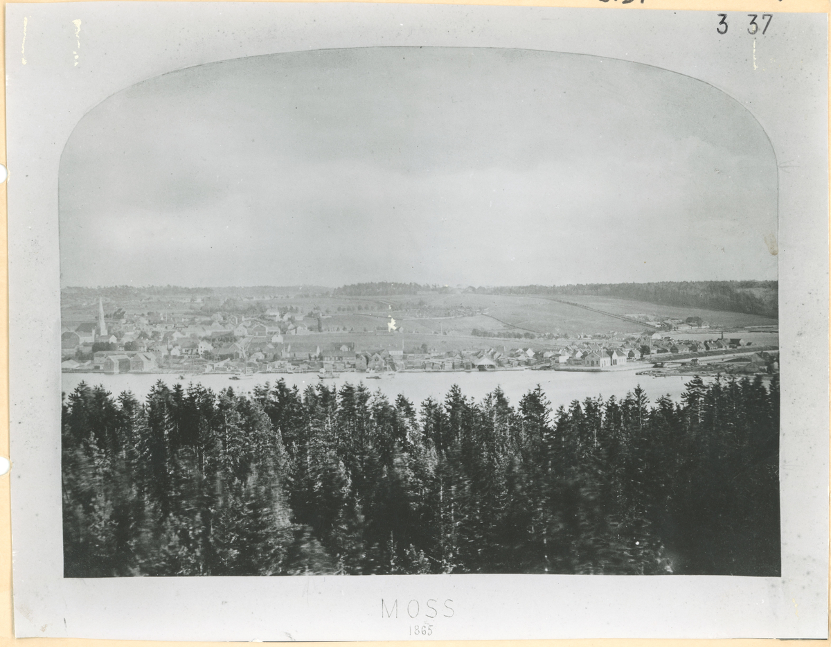 Utsikt fra Jeløy mot Mossesundet og kanalen. 2 bilder tatt fra samme sted. Trykk på pilen for neste bilde.

Bilde 1
Vi ser bebyggelse langs Værlegata, Storgata og kanalen. Moss kirkegård. Melløsbakkene. Tollboden.
Kanalen åpnet i 1853. Tollboden oppført i 1859. Kirkegård oppført i 1833. 

Bilde 2
Detaljer: Bebyggelse langs Enggaden(Dronningens gate) og Storgaden. Industri langs vannet. Moss kirke. Skarmyra.