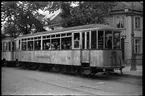 I Trondheim står en fullsatt släpvagn, AS Grpkallbanen, GB 51 vid hållplats på Gråkallbanen.