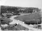 Vy över landskap, landsväg och järnväg vid Läggesta station innan en omläggning av järnväg och väg.