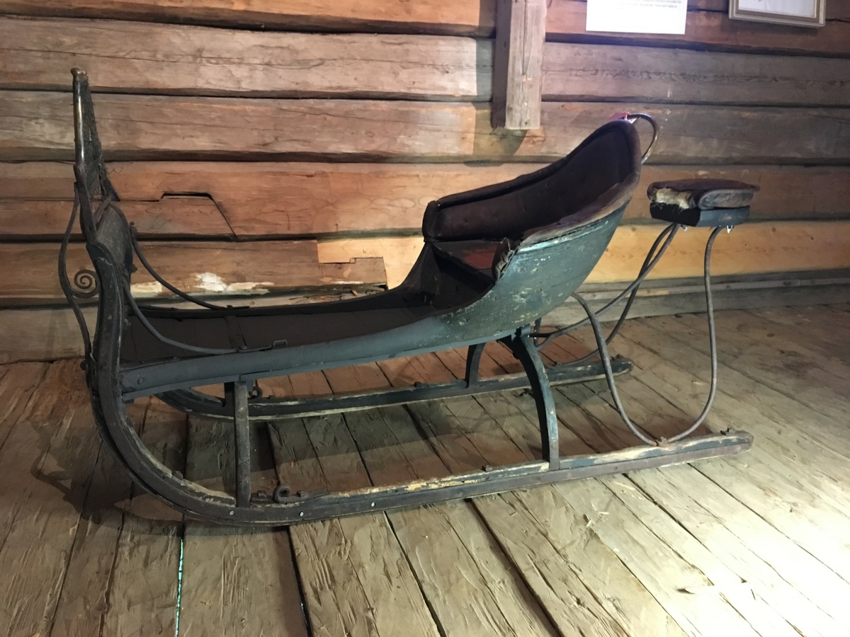 Spisslede av empiremodell fra før 1890. Forholdsvis stor, høy nettingskjerm foran. Romslig hovedsete trukket med skinn. Messingbelagt tomløper. Spesiell form på omramming på skvettskjerm. Smidde beslag, krussedull stiver av skjermen. Feste for skjeker (skjeker mangler). Sleden er reparert på museet. Personkjøretøy for hest til vinterføre brukt av kvinner og menn.
