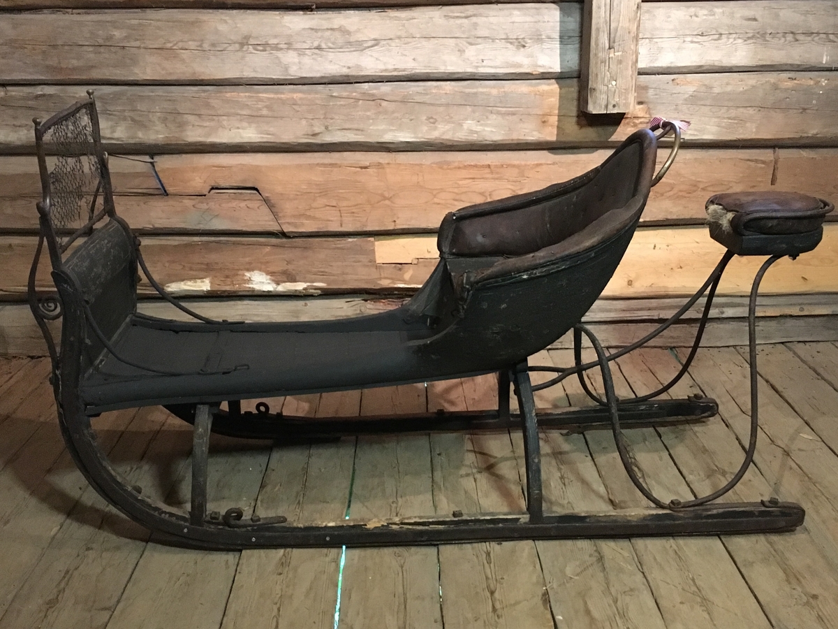 Spisslede av empiremodell fra før 1890. Forholdsvis stor, høy nettingskjerm foran. Romslig hovedsete trukket med skinn. Messingbelagt tomløper. Spesiell form på omramming på skvettskjerm. Smidde beslag, krussedull stiver av skjermen. Feste for skjeker (skjeker mangler). Sleden er reparert på museet. Personkjøretøy for hest til vinterføre brukt av kvinner og menn.