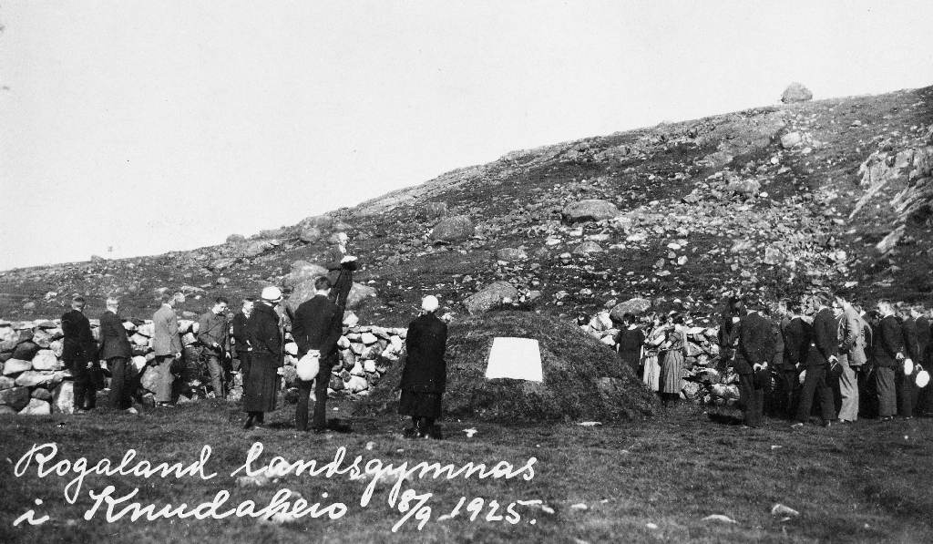 Elevar og lærarar frå Rogaland landsgymnas på skuletur 8. september 1925. Her er dei ved gravhaugen til Arne Garborg på Knudaheio omlag tre månader etter at urna var haugsett. Skulestyrar Edv. Brakstad heldt ein minnetale.