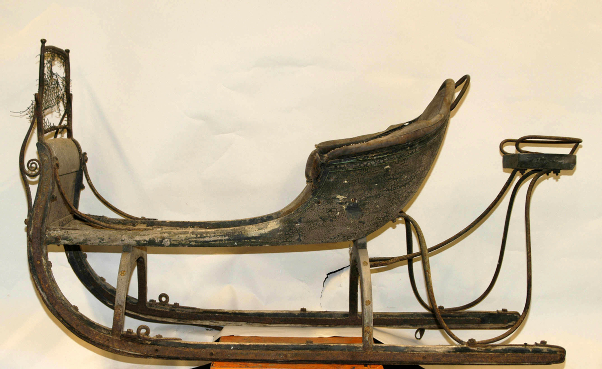 Spisslede av empiremodell fra før 1890. Forholdsvis stor, høy nettingskjerm foran. Romslig hovedsete trukket med skinn. Messingbelagt tomløper. Spesiell form på omramming på skvettskjerm. Smidde beslag, krussedull stiver av skjermen. Feste for skjeker (skjeker mangler). Sleden er reparert på museet. Personkjøretøy for hest til vinterføre brukt av kvinner og menn.
