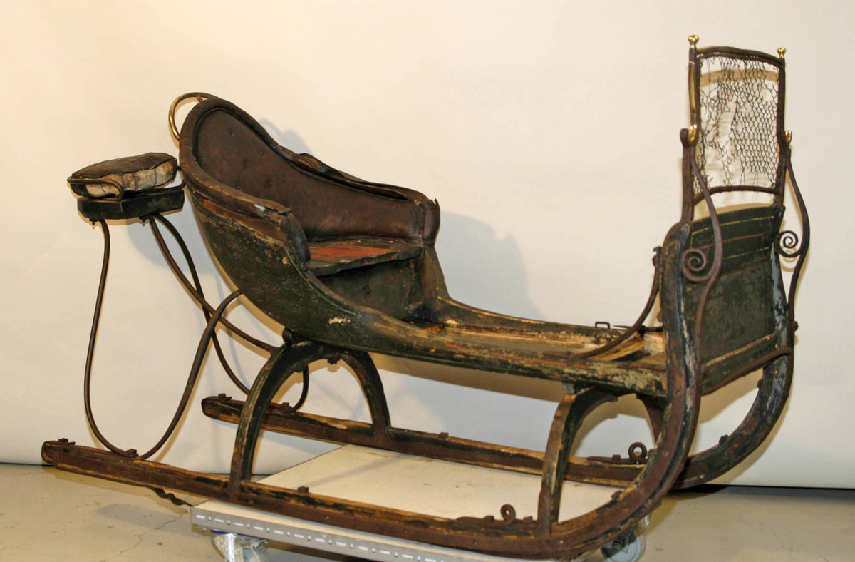 Spisslede av empiremodell fra før 1890. Forholdsvis stor, høy nettingskjerm foran. Romslig hovedsete trukket med skinn. Messingbelagt tomløper. Spesiell form på omramming på skvettskjerm. Smidde beslag, krussedull stiver av skjermen. Feste for skjeker (skjeker mangler). Sleden er reparert på museet. Personkjøretøy for hest til vinterføre brukt av kvinner og menn.