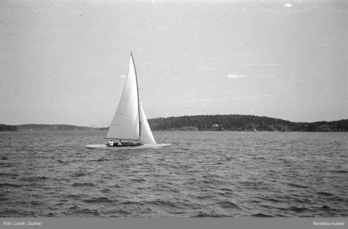 Motiv: Stockholm - Vaxholm;
Människor på en brygga med skylt "Edlunda", en segelbåt, människor på en brygga med skylt "Höganäs".

Motiv: Vaxholm;
Människor står på en brygga och en båt lägger till, en segelbåt, två män lyfter backar med flaskor på en brygga, folksamling vid möbler utställda på en grusplan (troligen en auktion).