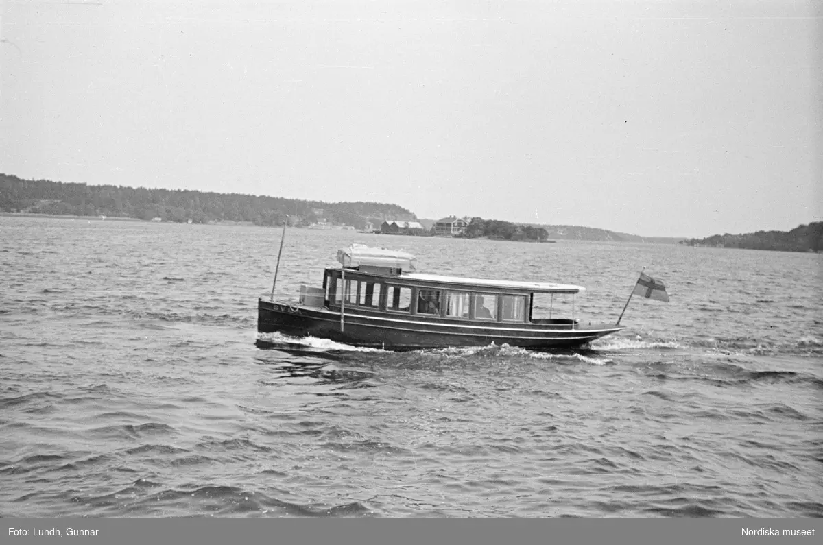 Motiv: Stockholm - Vaxholm;
Människor på en brygga med skylt "Edlunda", en segelbåt, människor på en brygga med skylt "Höganäs".

Motiv: Vaxholm;
Människor står på en brygga och en båt lägger till, en segelbåt, två män lyfter backar med flaskor på en brygga, folksamling vid möbler utställda på en grusplan (troligen en auktion).