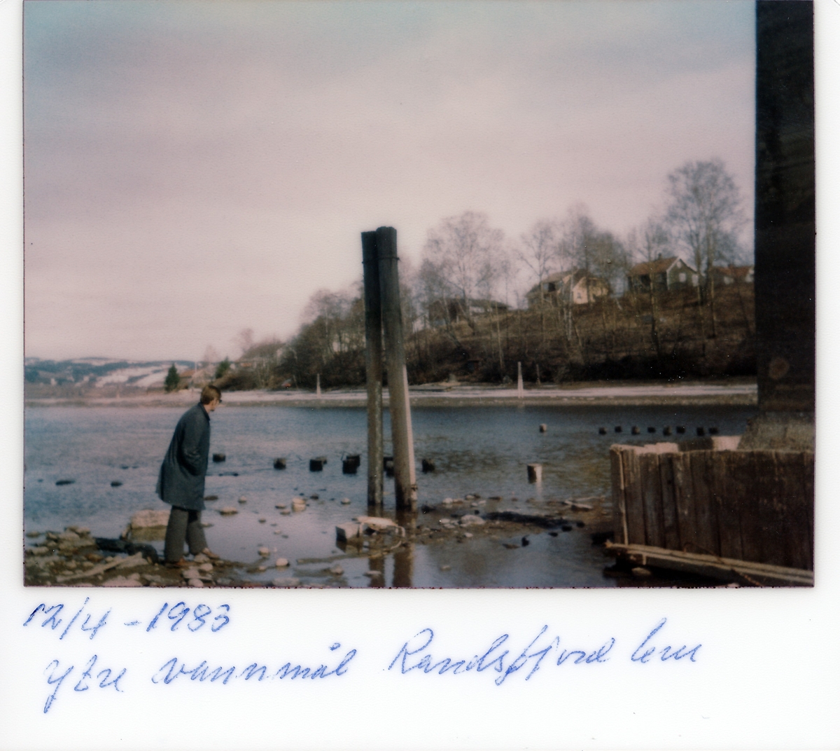 Mann på stranden fotografert ved ytre vannmål ved Randsfjord bru i Randsfjorden. Nesbakken i bakgrunnen.