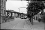 Vid Västkustbane viadukten på Drottninggatan vid Halalid står Helsingborgs Stads Spårvägar, HSS spårvagnar vid hållplats på linje 1.