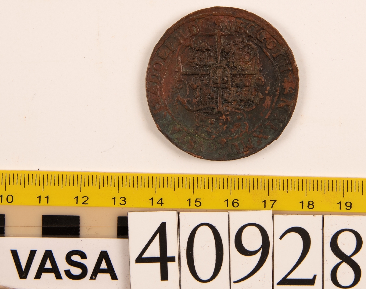 1 öre
Runt mynt.
Åtsidan: mitt på myntet det svenska riksvapnet, svagt delvis synligt.
Omskriften med Gustav Adolfs regent titlar svagt delvis synlig.
Ocentrerad prägling.
Frånsidan: två korsade pilar under en krona, svagt delvis synliga.
Till vänster höger om pilarna siffran 1, till höger versalerna ÖR, svagt delvis synliga. Omskriften på latin med bland annat präglingsåret i romerska siffror, 1627, är delvis läsligt delvis oläsligt.
Ocentrerad prägling.
Nuvarande skick: bägge sidor slitna. Åtsidan sliten, frånsidan sliten. Jack, valsklump, korroderat, krackelerat.