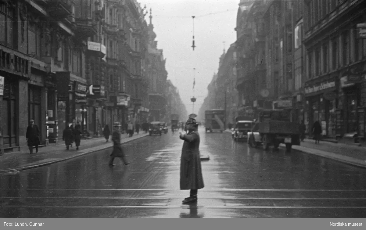Motiv: Tyskland, Rankestrasse, Berlin, fröken Andersson, fru Rydelius;
Porträtt av två kvinnor som går på en stadsgata, en kvinna med svarta glasögon sitter i en port, stadsvy med fotgängare och en spårvagn.

Motiv: Tyskland, Berlin bl. a. Fredrichstrasse;
Skyltfönster med text "Gr. Mittagtisch! Kein Bedienungsgeld Kein Trinkzwang" och ett plakat uppsatt på fönstret, stadsvy med fotgängare och bilar, skyltfönster med text "Grog von Rum ....." "Fernsprechen", skyltfönster med text "Mittag u. Abend Gedeck 50" "Hier essen Sie besser und billiger" "Speise - Restaurant", skyltfönster med text "Gedecke bis 7 Uhr Abends 3 Gänge - 50 Grosse Auswahl."