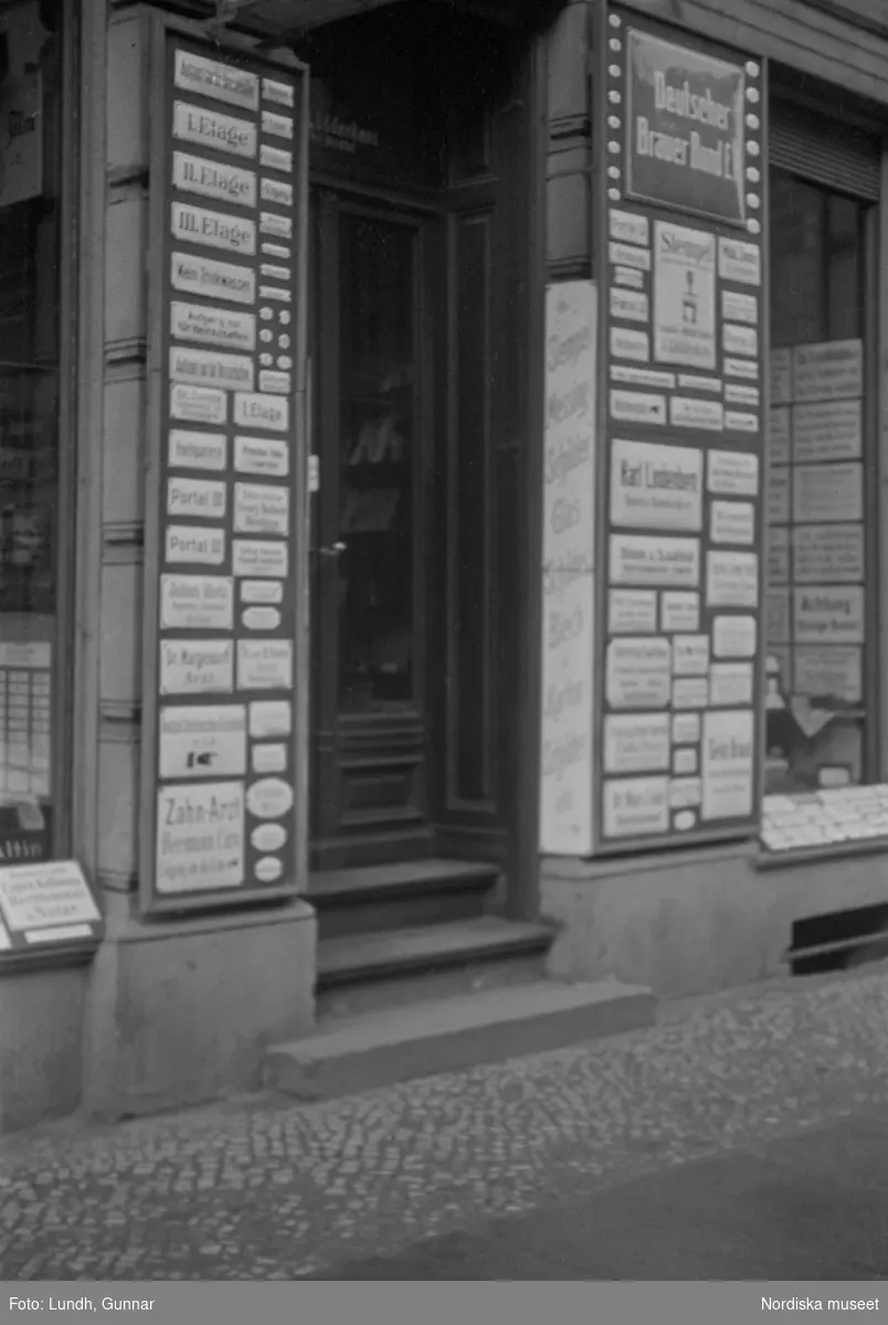 Motiv: Tyskland, Rankestrasse, Berlin, fröken Andersson, fru Rydelius;
Porträtt av två kvinnor som går på en stadsgata, en kvinna med svarta glasögon sitter i en port, stadsvy med fotgängare och en spårvagn.

Motiv: Tyskland, Berlin bl. a. Fredrichstrasse;
Skyltfönster med text "Gr. Mittagtisch! Kein Bedienungsgeld Kein Trinkzwang" och ett plakat uppsatt på fönstret, stadsvy med fotgängare och bilar, skyltfönster med text "Grog von Rum ....." "Fernsprechen", skyltfönster med text "Mittag u. Abend Gedeck 50" "Hier essen Sie besser und billiger" "Speise - Restaurant", skyltfönster med text "Gedecke bis 7 Uhr Abends 3 Gänge - 50 Grosse Auswahl."