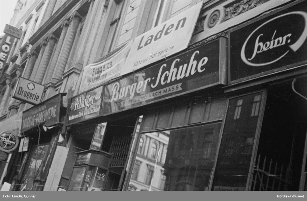 Motiv: Tyskland, Berlin bl. a. Friedrichstrasse;
Detalj av fasad med skylt "Zu vermieten ...", skylt "Warum kommen Sie nicht zu uns? ....", en man säljer tidningar.

Motiv: Tyskland, Vorwärts, Reinickendorf;
Gatuvy med människor vid en spårvagn, gatuvy med fotgängare - bilar och en hästdragen vagn, porträtt av en man "Apolant m fru", gatuvy med fotgängare.
