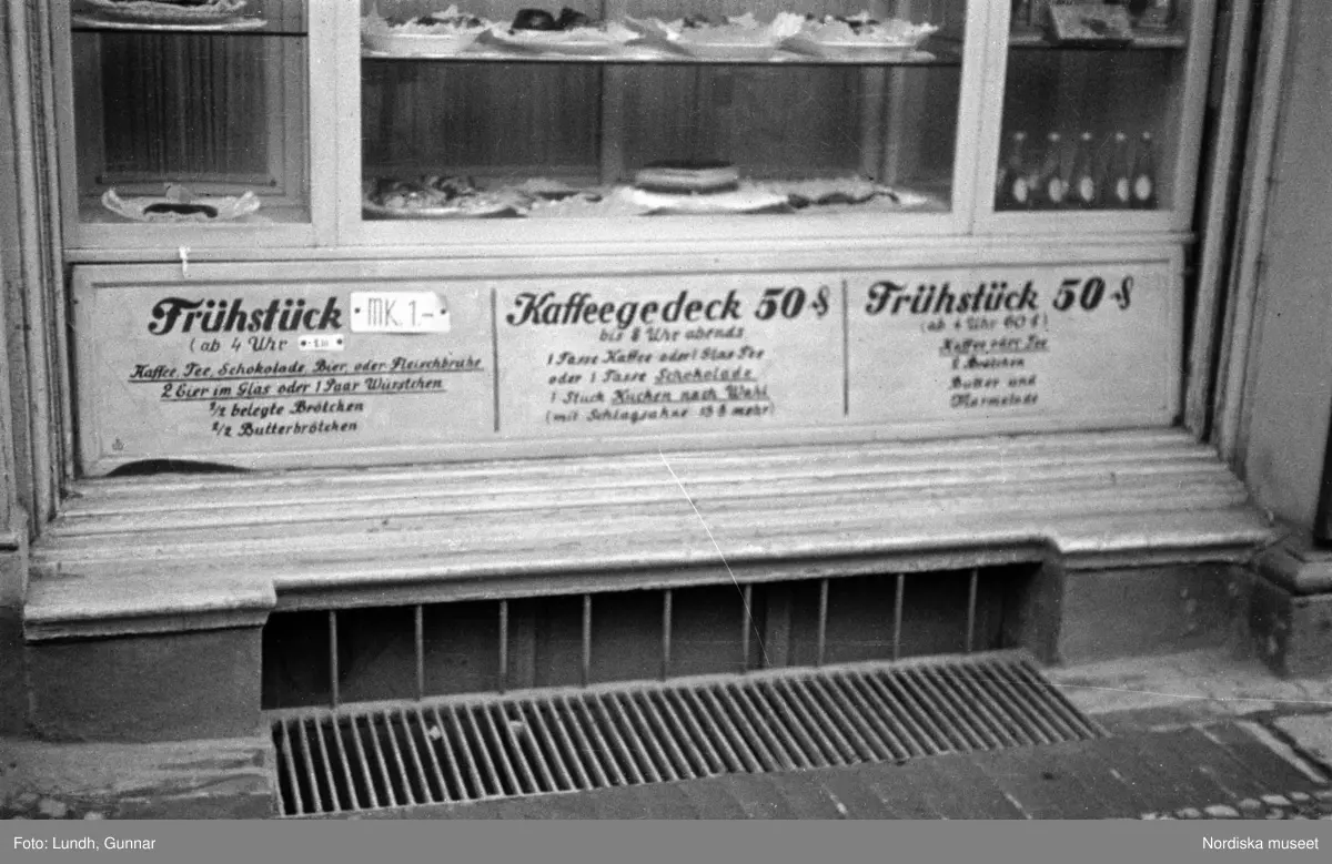 Motiv: Tyskland, Berlin bl. a. Friedrichstrasse;
Detalj av fasad med skylt "Zu vermieten ...", skylt "Warum kommen Sie nicht zu uns? ....", en man säljer tidningar.

Motiv: Tyskland, Vorwärts, Reinickendorf;
Gatuvy med människor vid en spårvagn, gatuvy med fotgängare - bilar och en hästdragen vagn, porträtt av en man "Apolant m fru", gatuvy med fotgängare.