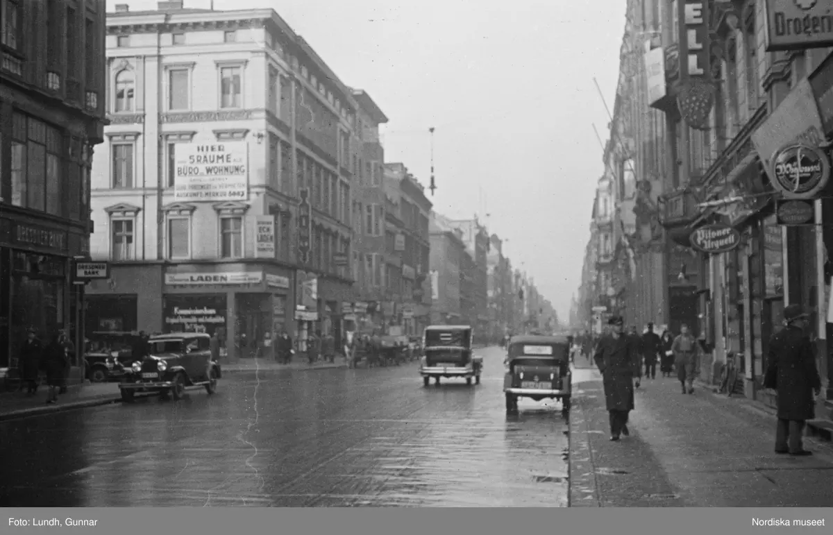 Motiv: Tyskland, Berlin bl. a. Friedrichstrasse;
Detalj av fasad med skylt "Zu vermieten ...", skylt "Warum kommen Sie nicht zu uns? ....", en man säljer tidningar.

Motiv: Tyskland, Vorwärts, Reinickendorf;
Gatuvy med människor vid en spårvagn, gatuvy med fotgängare - bilar och en hästdragen vagn, porträtt av en man "Apolant m fru", gatuvy med fotgängare.