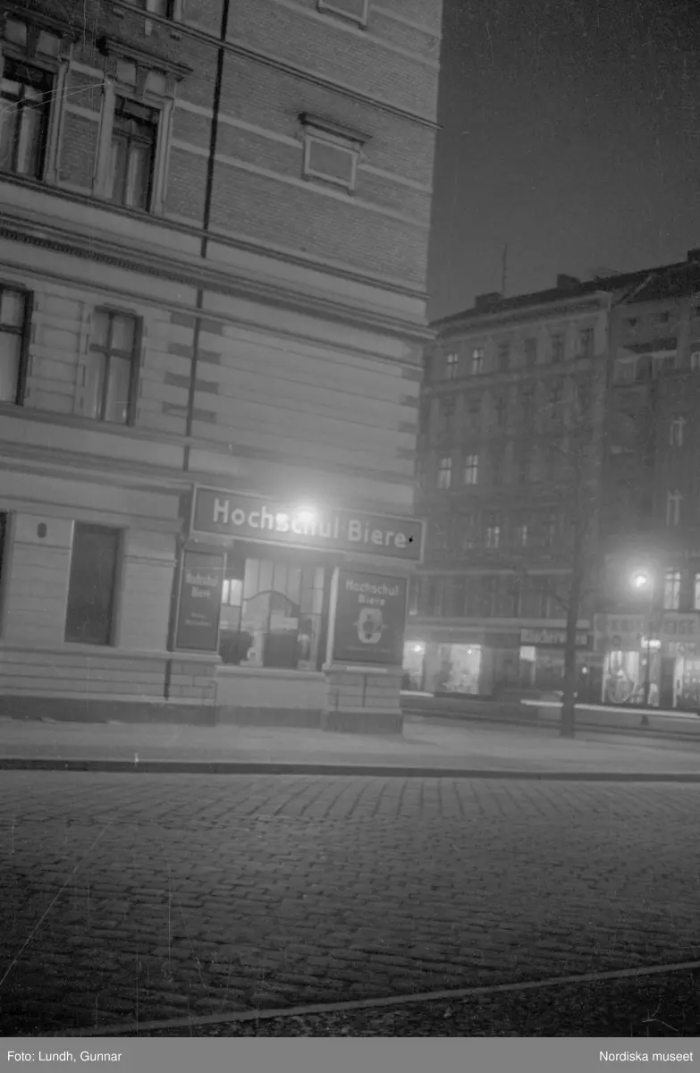 Motiv: Tyskland, Vorwärts, Reinickendorf;
Skylt "Grenzallee (Neukölln) Nach Tempelhof ....", två män står vid ett upplyst skyltfönster.

Motiv: Tyskland, Kurfurstendamm;
Exteriör av en kyrka, detalj av en fasad.
