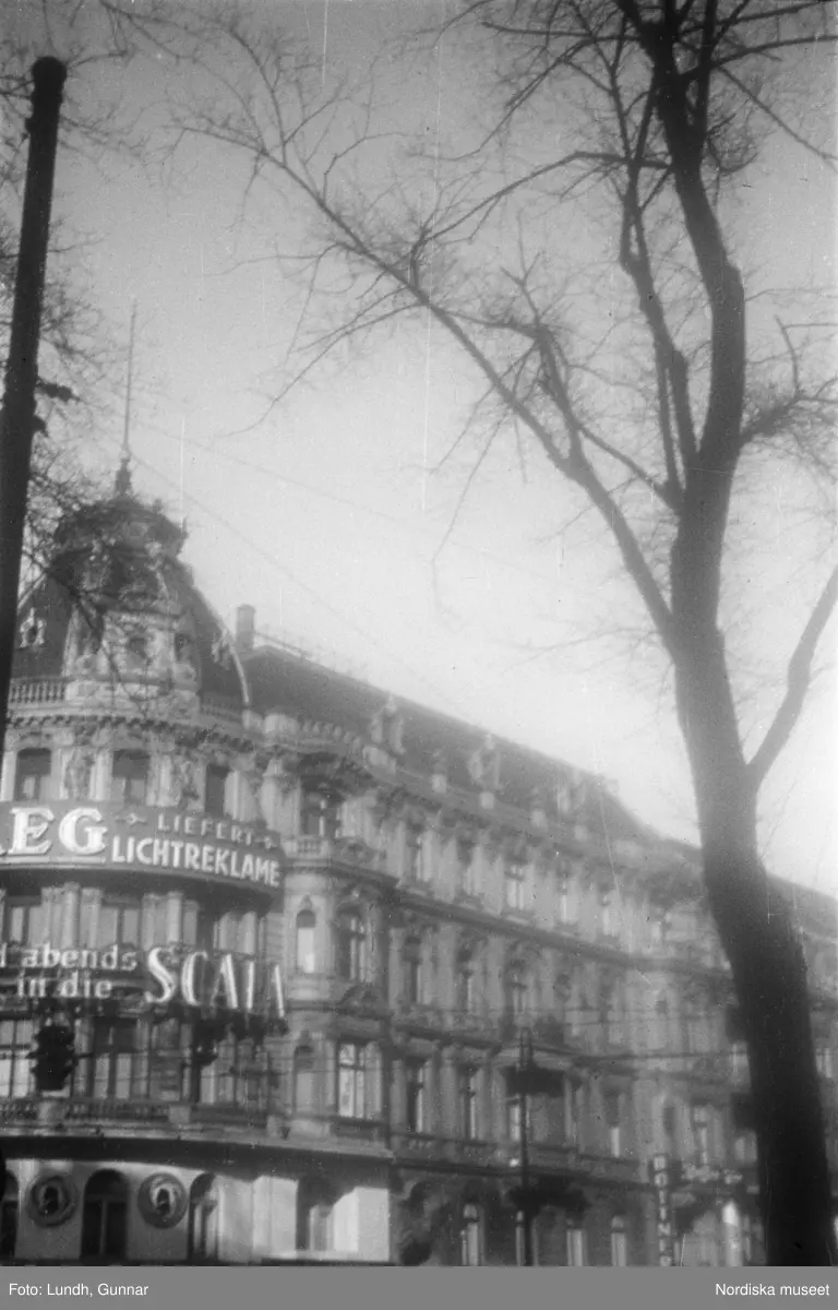 Motiv: Tyskland, Vorwärts, Reinickendorf;
Skylt "Grenzallee (Neukölln) Nach Tempelhof ....", två män står vid ett upplyst skyltfönster.

Motiv: Tyskland, Kurfurstendamm;
Exteriör av en kyrka, detalj av en fasad.