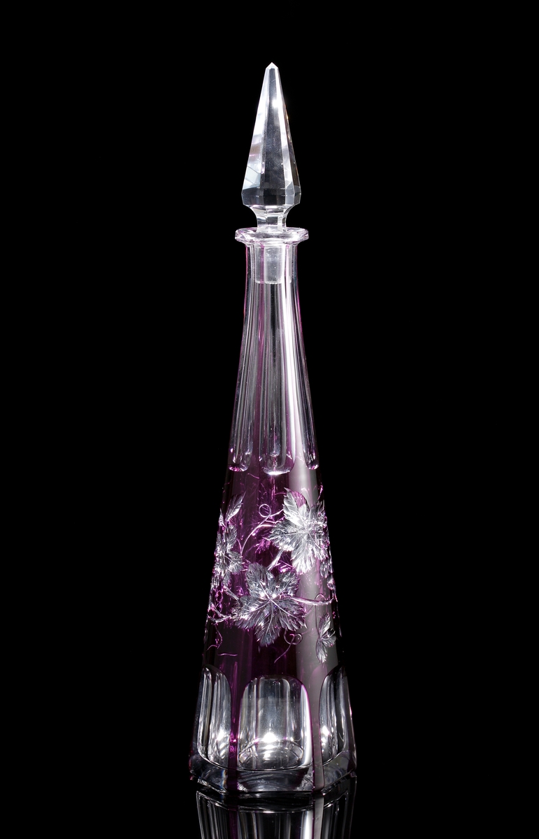 Karaff med violett överfång. Slipad dekor med vinrankor samt facettslipade partier.