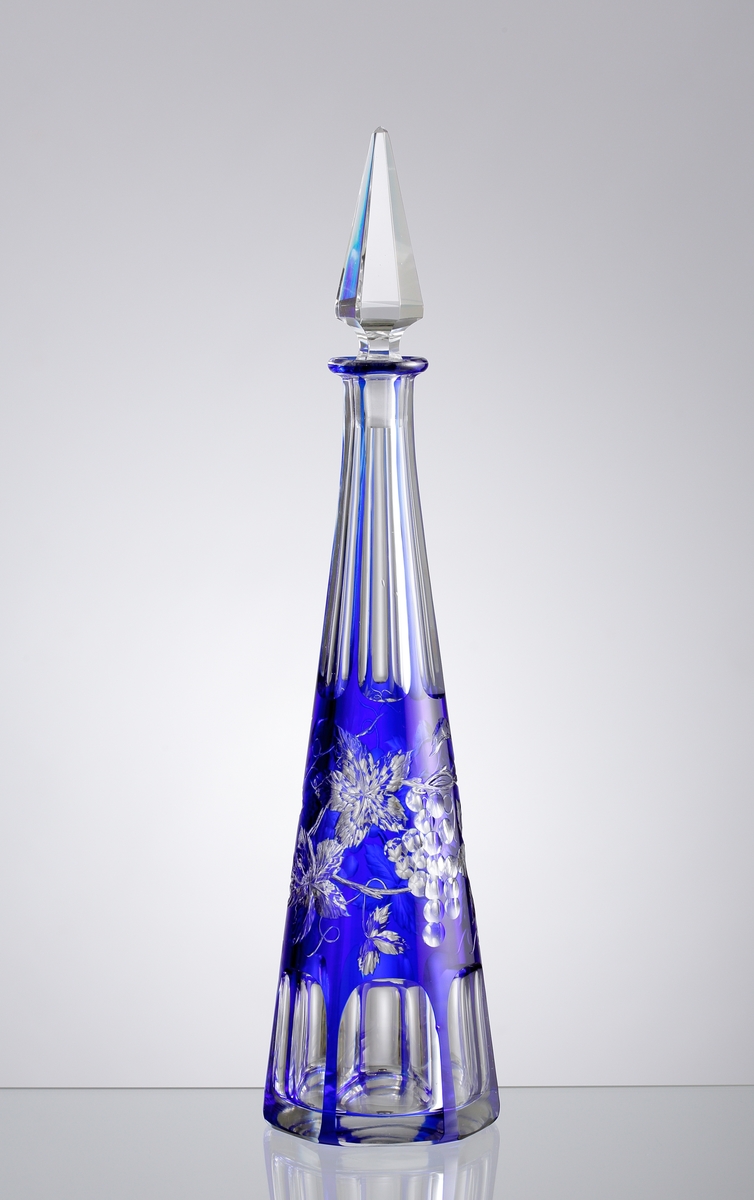 Karaff med blått överfång. Slipad dekor med vinrankor samt facettslipade partier.