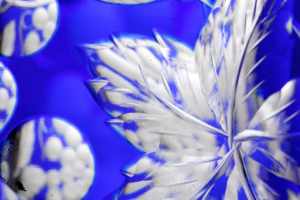 Karaff med blått överfång. Slipad dekor med vinrankor samt facettslipade partier.