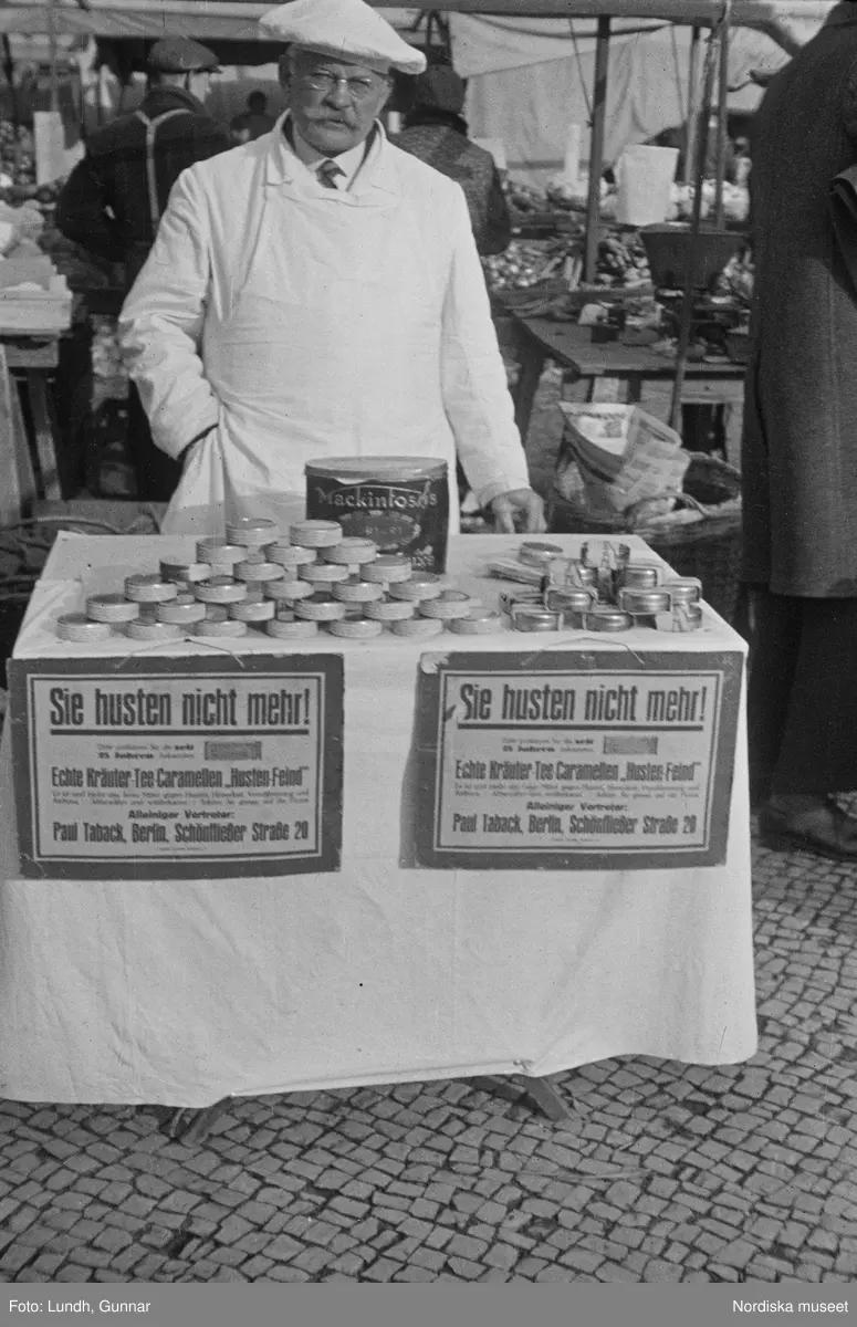 Motiv: Tyskland, Berlin;
Porträtt av en man "Tiller" som dricker ur ett glas.

Motiv: Tyskland, Berlin;
Utsikt från ett restaurangfönster över ett torg med torghandel, en man står vid ett försäljningsstånd med skylt "Sie husten nicht mehr!.....", gatuvy med en cyklist och en bil, gatuvy med bilar och en man som skjuter en kärra med text "G. Pabst Lack-Fabrik", skylt "Diese Villen sind im ganzen oder geteilt zu vermieten.....", grind med skyltar "Prof. Georg Klempener" "Professor Dr. A. Pinkuss", gatuvy med an man som samtalar med en kvinna, ett bord på gatan med böcker till försäljning, skylt "5 zimmer wohnung 1 etage auch geteilt per 1. april näheres b. wirt.", exteriör av byggnad med stor skylt på fasaden "Zu vermieten....", gatuvy med bilar - spårvagn - man med handkärra och en man som sopar gatan.