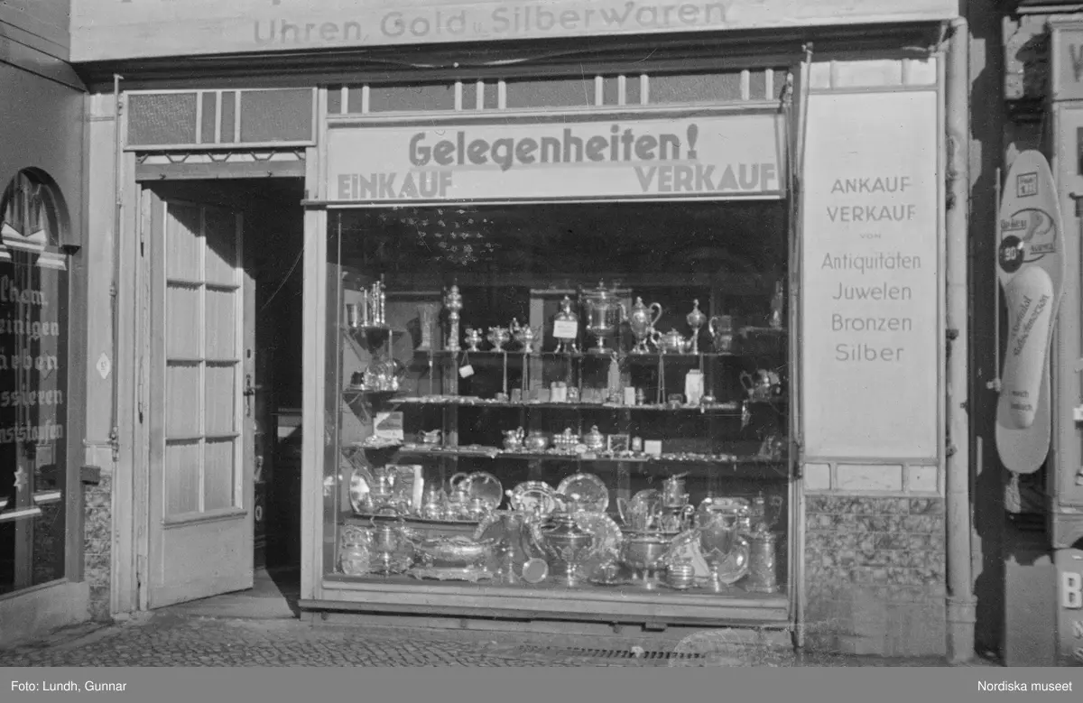 Motiv: Tyskland, Berlin;
Porträtt av en man "Tiller" som dricker ur ett glas.

Motiv: Tyskland, Berlin;
Utsikt från ett restaurangfönster över ett torg med torghandel, en man står vid ett försäljningsstånd med skylt "Sie husten nicht mehr!.....", gatuvy med en cyklist och en bil, gatuvy med bilar och en man som skjuter en kärra med text "G. Pabst Lack-Fabrik", skylt "Diese Villen sind im ganzen oder geteilt zu vermieten.....", grind med skyltar "Prof. Georg Klempener" "Professor Dr. A. Pinkuss", gatuvy med an man som samtalar med en kvinna, ett bord på gatan med böcker till försäljning, skylt "5 zimmer wohnung 1 etage auch geteilt per 1. april näheres b. wirt.", exteriör av byggnad med stor skylt på fasaden "Zu vermieten....", gatuvy med bilar - spårvagn - man med handkärra och en man som sopar gatan.