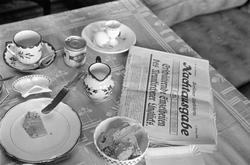 Motiv: Tyskland:
Ett dukat frukostbord med en tidning "Nacht